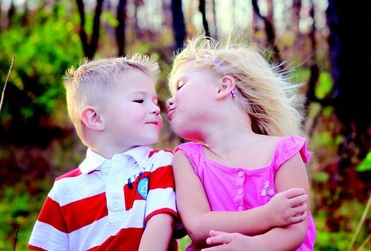 cute baby girl and boy kissing